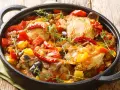 Sobracosce di pollo stufate con peperoni, pomodori, melanzane e peperoncino, guarnite con timo fresco.