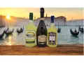 Weneckie gondole i zachód słońca tworzą tło dla butelek limoncello i prosecco, idealnych na orzeźwiający limoncello spritz.