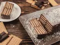 Tarta de chocolate y galletas, un postre casero con capas de galletas y crema de chocolate, espolvoreada con coco rallado.