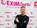 Mężczyzna na tle logo EXIM tours. Czy to zapowiedź bankructwa?