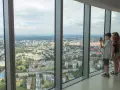Widok z tarasu widokowego Sky Tower. Rodzina podziwia panoramę miasta, doceniając jego ogromną wysokość.