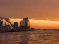Coucher de soleil sur le port de Hambourg, idéal pour visiter Hambourg en 3 jours. Bateaux, grues et la Philharmonie de l'Elbe se reflètent sur l'eau.