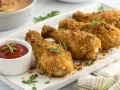 Pilon de poulet croustillants, parfaits pour une recette facile. Servi avec une sauce tomate et des herbes fraîches.