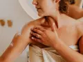 Kobieta nakłada balsam brązujący który nie brudzi ubrań na ramię.