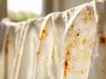 Tessuti bianchi appesi con macchie arrugginite. Scopri come togliere le macchie di ferro dai tessuti per farli tornare come nuovi.