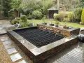 Estanque con cascadas y bonsáis, ideal para recoger agua de lluvia. Un oasis zen en el jardín.