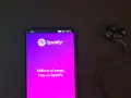 Telefon z aplikacją Spotify i słuchawkami. Idealne do słuchania wzruszających piosenek o przyjaźni.