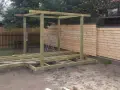 Budowa altany z palet krok po kroku: drewniana konstrukcja z fundamentami z bloczków betonowych, gotowa do dalszych prac.
