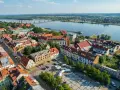 Widok z lotu ptaka na Płock, Wisłę i most. Widać zabytkowe kamienice, katedrę i rynek, które są głównymi atrakcjami w Płocku.
