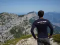 Un cycliste admire le panorama après un **tour du Vercors 7 jours**. Le paysage montagneux est spectaculaire.