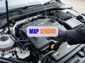 Ręka w rękawiczce mechanika wskazuje na silnik TDI. Napis "MAP SENSOR" sugeruje, że chodzi o objawy awarii tego elementu.