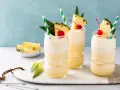 Trzy orzeźwiające drinki bezalkoholowe Mocktail kontra klasyczny koktajl, udekorowane ananasem i wiśnią.