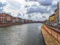 Spacerem wzdłuż rzeki w Pizie, podziwiając kolorowe kamienice i burzowe chmury.