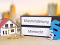 Hausmodell, Waage, Ordner mit "Mietminderung" & "Mietrecht" & Paragraphenzeichen. Wenn der Vermieter seinen Pflichten nicht nachkommt, ist das Mietrecht gefragt.