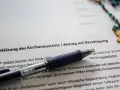 Dokument zur Kirchenaustrittserklärung mit Stift und Rosenkranz. Der Text erwähnt "Kirchensteuer bezahlen", was auf eine mögliche Kirchensteuererstattung hindeutet.