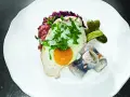 Labskaus mit Spiegelei, Rollmops und Gewürzgurken. Die Herkunft dieses norddeutschen Gerichts ist Seefahrer-Tradition.