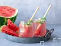 Orzeźwiający drink z arbuzem i miętą, podany na tacy z kawałkami arbuza i kostkami lodu. Idealny na upalne dni.