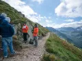 Grupa turystów na skalistej ścieżce w Tatrach. Czy trasa na Kasprowy Wierch jest trudna? Widok na góry i chmury.