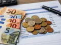 Euro banknoty i monety na arkuszu kalkulacyjnym. Szukasz pracy w Rotterdamie? Agencje pracy pomogą Ci znaleźć zatrudnienie.