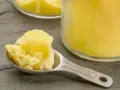 Łyżka z masłem klarowanym, czyli ghee. Zastanawiasz się, ghee co to? To złocisty tłuszcz, idealny do smażenia.