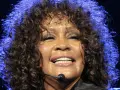Whitney Houston z zamkniętymi oczami, w pełni emocji, pokazuje niesamowitą **skalę głosu**.