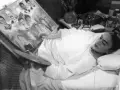 Frida Kahlo målar i sängen, omgiven av sina porträtt av familj och vänner, kanske sina syskon.