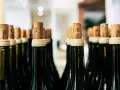 Rzędy butelek z korkami, gotowe na degustację. Każdy korek to obietnica smaku, jak wino wytrawne po włosku.
