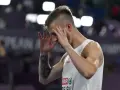 Norbert Kobielski, lekkoatleta, zamyka oczy, skupiając się przed ważnym startem.
