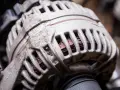 Zniszczony alternator, widoczne uzwojenia. Objawy awarii mogą być różne, od problemów z ładowaniem po kontrolkę na desce.