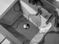 Évier en béton gris avec des veines sombres, robinetterie moderne. La différence évier lavabo est subtile, mais ici, c'est un lavabo design.