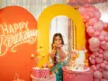 Kolorowe przyjęcie urodzinowe z neonowym napisem "Happy Birthday", tortem i konfetti. Fajne pomysły na urodziny dla nastolatków!