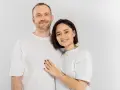Uśmiechnięta para, on z zarostem, ona z tatuażem na szyi. Idealni do rozmowy o pytania na randkę.