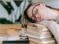 Zmęczona studentka zasnęła na stosie książek, zastanawiając się, psychoza co to.