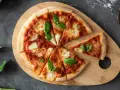 Margherita na desce z drewna. Proste ciasto na pizzę zawsze wychodzi, ozdobione pomidorami, mozzarellą i bazylią.