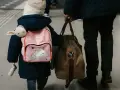 Enfant avec sac à dos licorne et doudou, accompagnant un adulte. Voyage pour une autorisation de sortie de territoire mineur parents séparés.