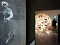 Exposition Albert Kahn : une femme en costume traditionnel sur une photo ancienne, un globe de bois rempli de clichés en arrière-plan.