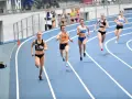 Aneta Lemiesz biegnie w zawodach lekkoatletycznych, walcząc o zwycięstwo na bieżni.