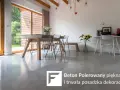 Jasna, polerowana podłoga betonowa w nowoczesnym salonie z drewnianymi elementami i dużymi oknami.