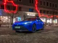 Niebieska Toyota Mirai na nocnej ulicy z neonowym oświetleniem.