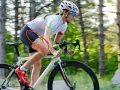 Cyclist experiencing quad pain during a ride, highlighted by a red circle on her thigh.