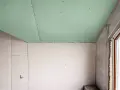 Jonction mur plafond placo, avec un plafond vert et des murs blancs. Travaux de rénovation en cours.