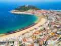 Widok z lotu ptaka na zatokę La Concha w San Sebastian, z piaszczystą plażą, turkusową wodą i zabudową miejską.