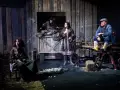 Scena z dramatu. Cztery postacie w wiejskiej scenerii, napięcie w powietrzu. Co to za dramat?