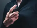 Mann sprüht sich Parfum auf die Brust.