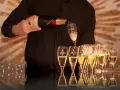Kelner nalewa szampan Moët & Chandon do kieliszków, przygotowując się do wesela.