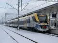 Pociąg EN78A-008 B relacji R34 Katowice stoi na zaśnieżonym peronie. Podróżuj taniej z bliskimi, wybierając kolej.