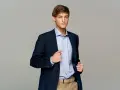 Elegancki mężczyzna w granatowej marynarce i błękitnej koszuli. Idealny przykład, jak się ubrać na imprezę firmową, by wyglądać stylowo i profesjonalnie.