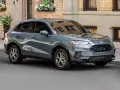Elegancki, szary SUV Honda HR-V stoi na ulicy przed budynkiem z cegły.