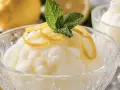 Sorbetto al limone senza albume, fresco e profumato, guarnito con scorzette di limone e foglioline di menta.