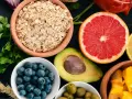 Assortiment de fruits et légumes : flocons d'avoine, myrtilles, avocat, pamplemousse, citron, olives, mangue. Attention aux aliments mauvais pour la flore intestinale.